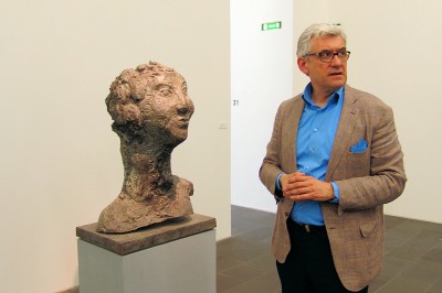 Smerling neben einer Skulptur von Markus LÜPERTZ